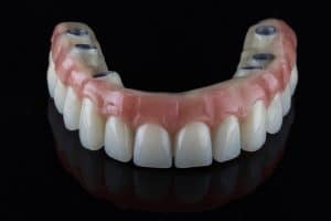 Dental upper jaw prosthesis with fixation on six implants, shot on a black background